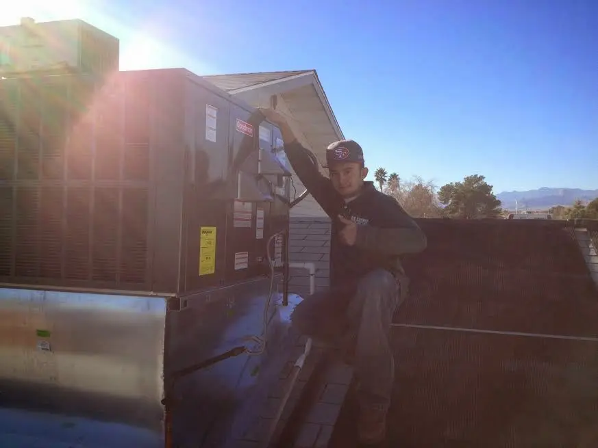 HVAC technician performing HVAC Inspection on a rooftop unit in Junction City